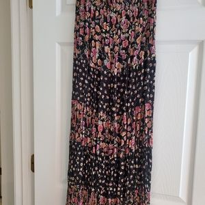 Indira long pleated skirt, black background with mauve and light brown flowers.